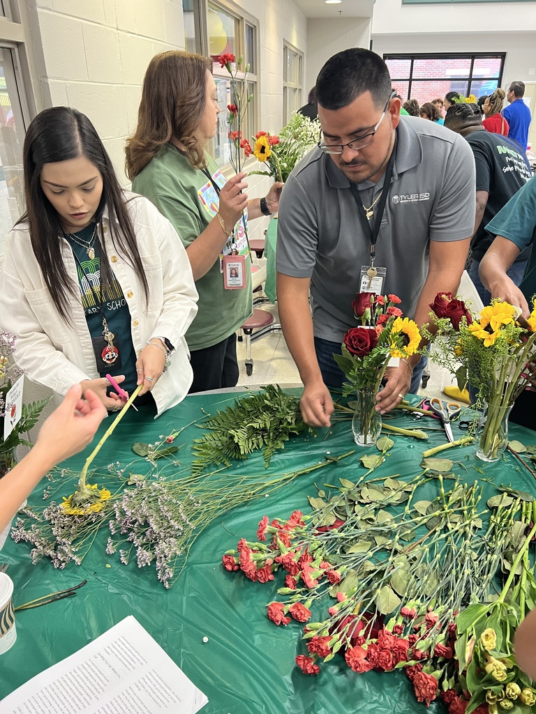 People surrounding a table covered in flowers