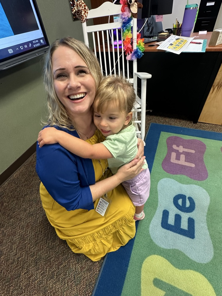 teacher and student hugging and smiling