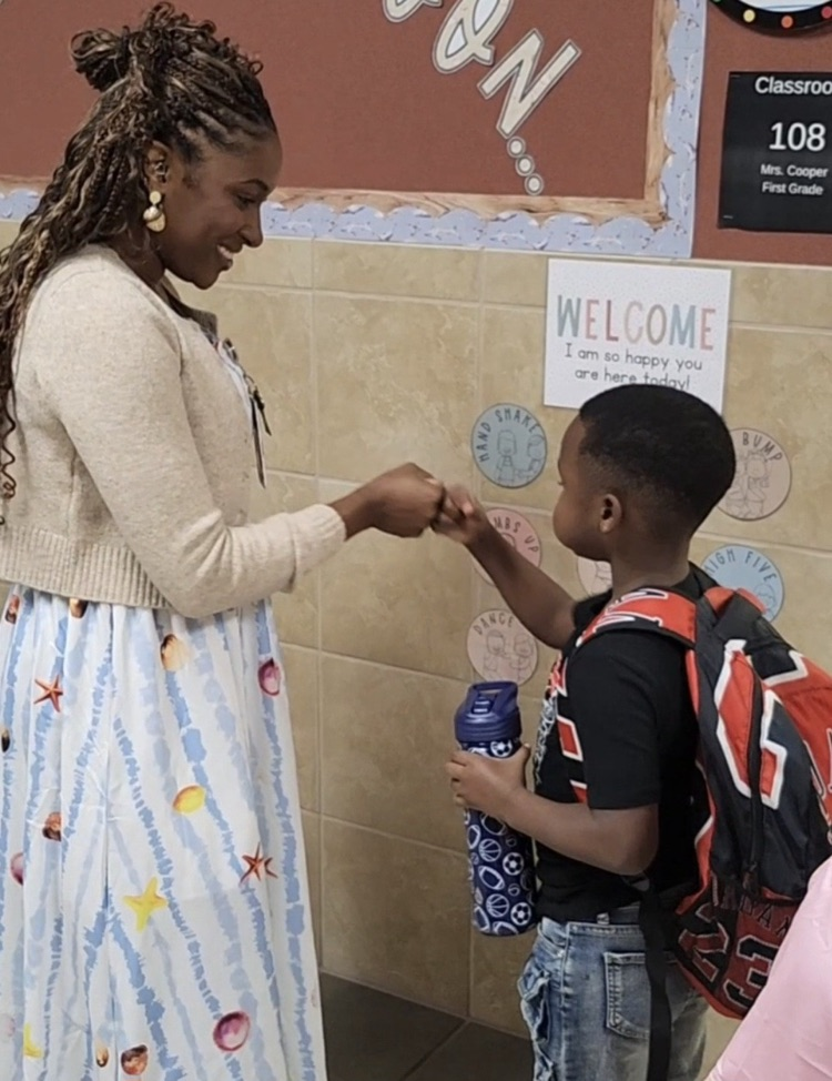 teacher fist bumping student