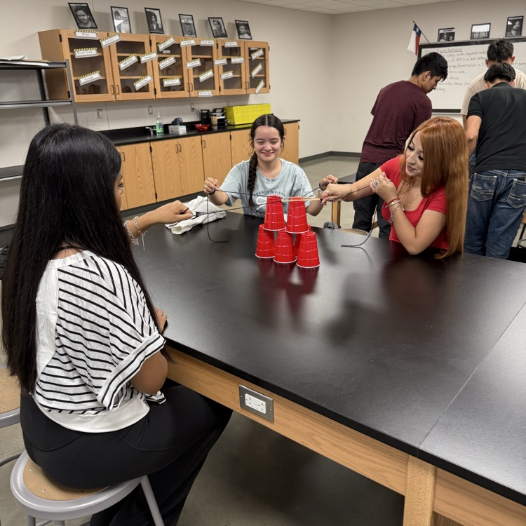 students at lab table with tower of cups