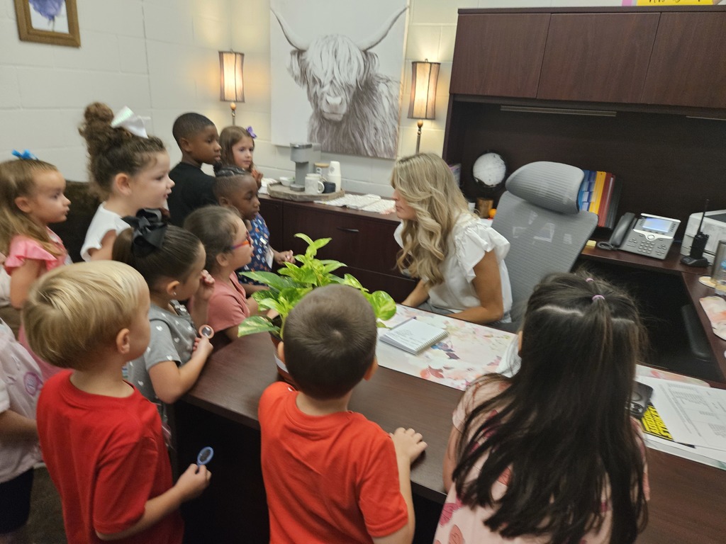 Kindergarten student's getting gingerbread cookies from the principal.