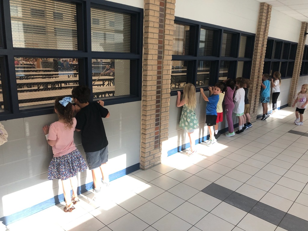 Students looking for the gingerbread man through windows.