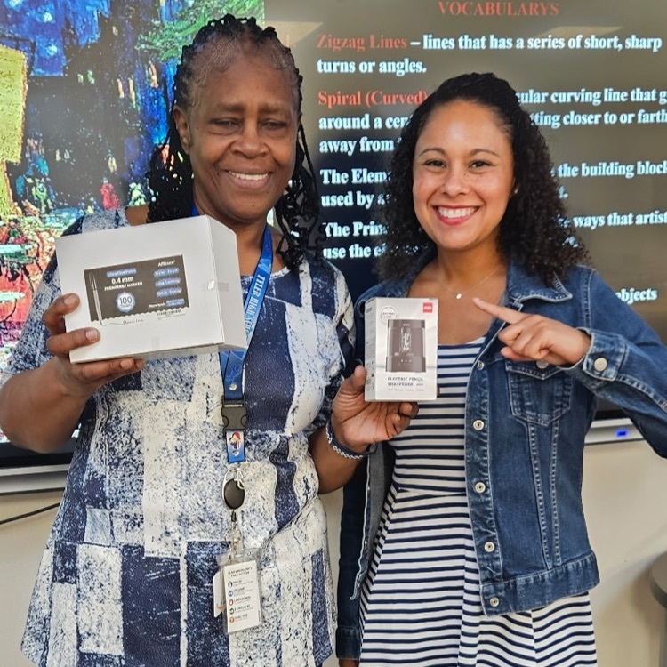 two ladies holding art supplies
