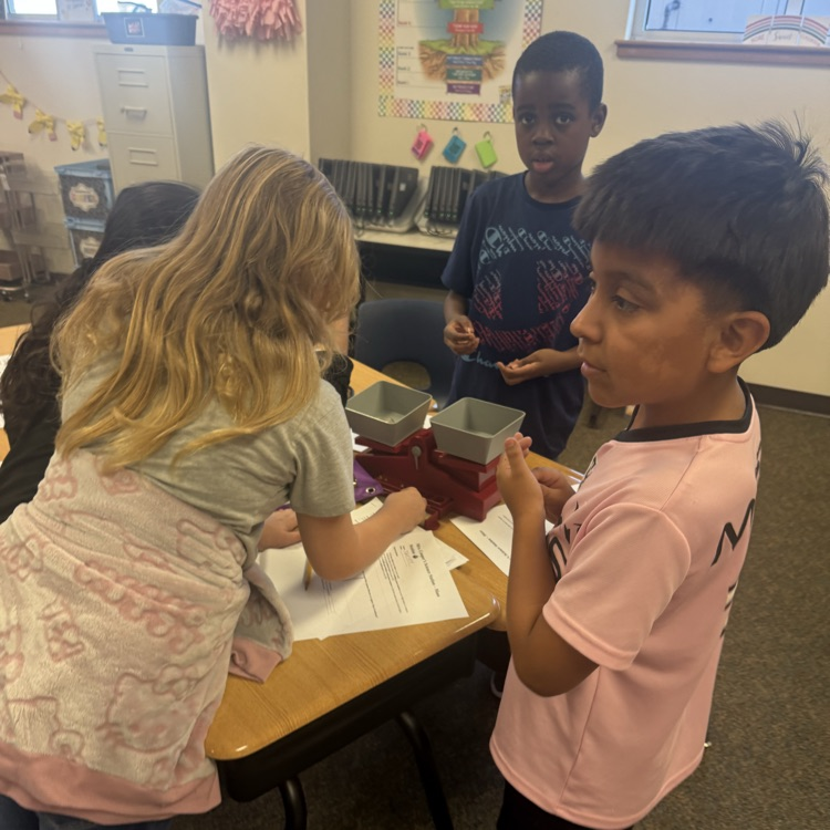 Third graders working together to measure mass in a lab experiment