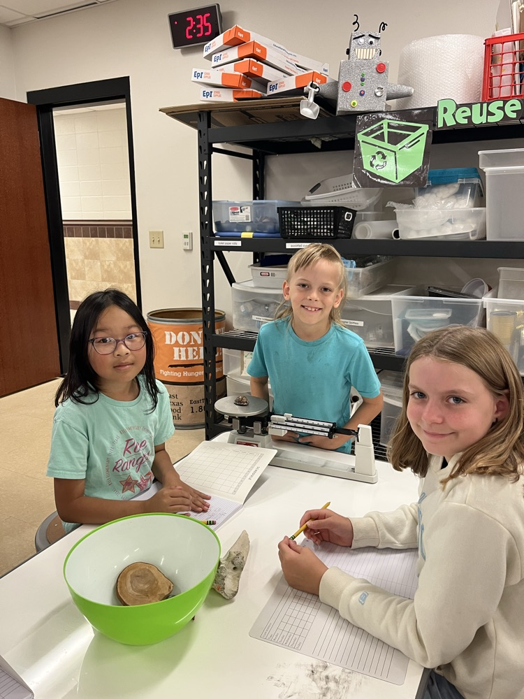 students measuring mass using a triple beam balance