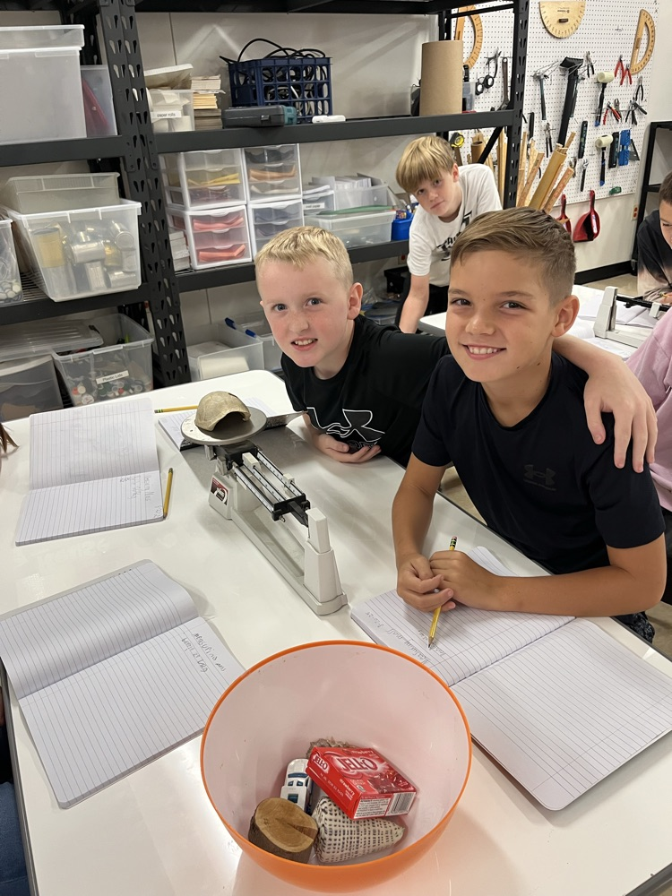 students measuring mass using a triple beam balance