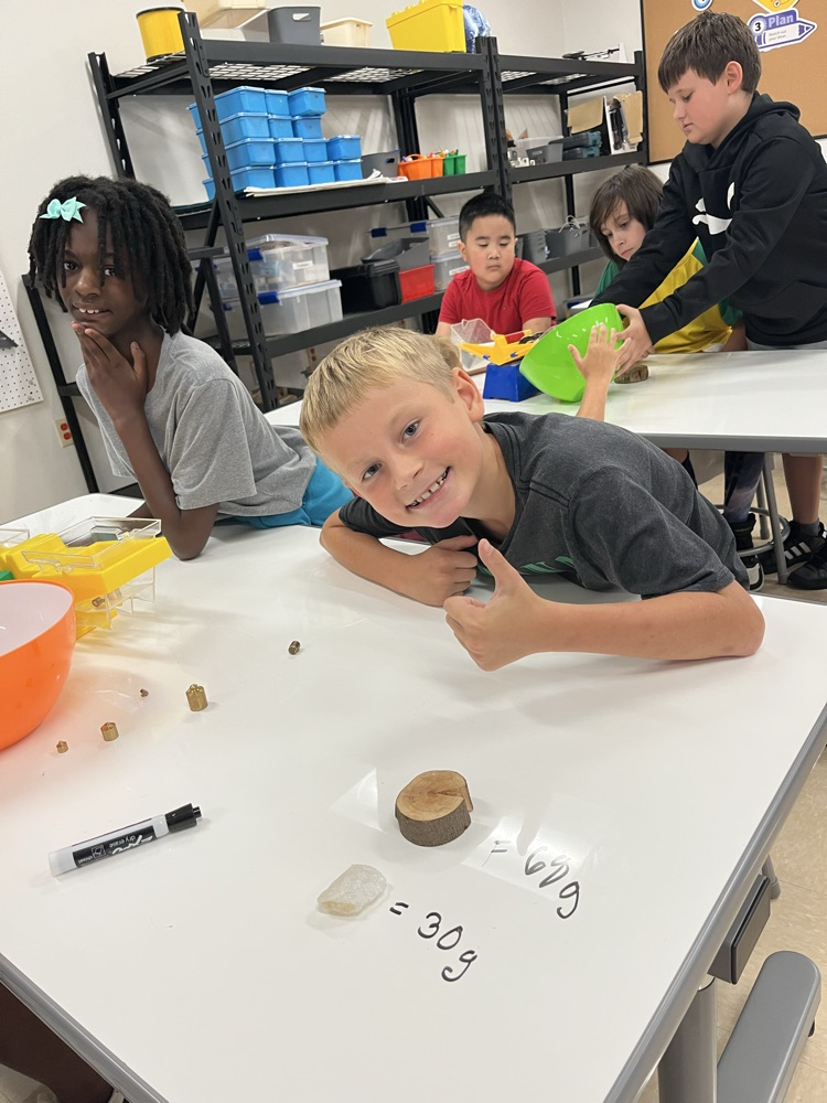 students measuring mass using a triple beam balance