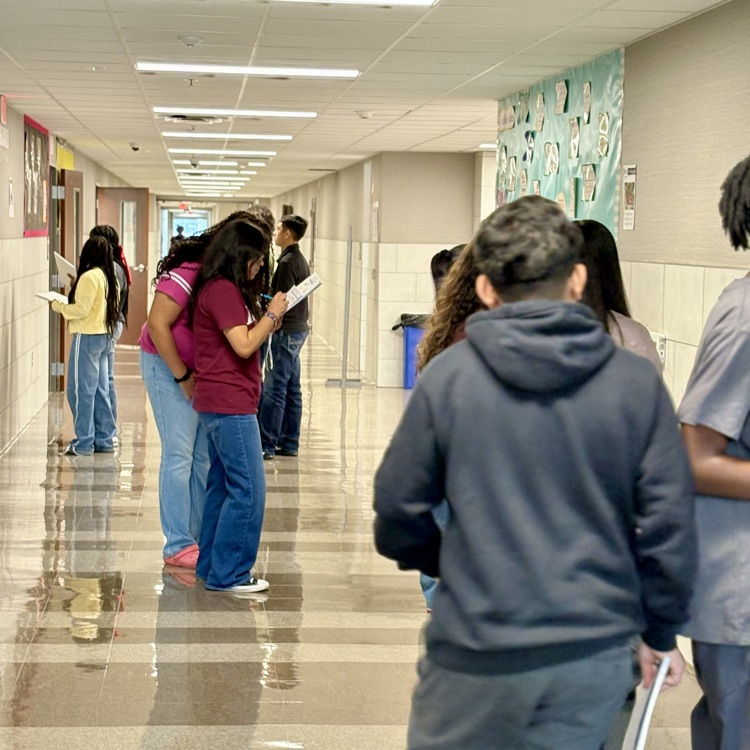students in the hallway looking at advertisements
