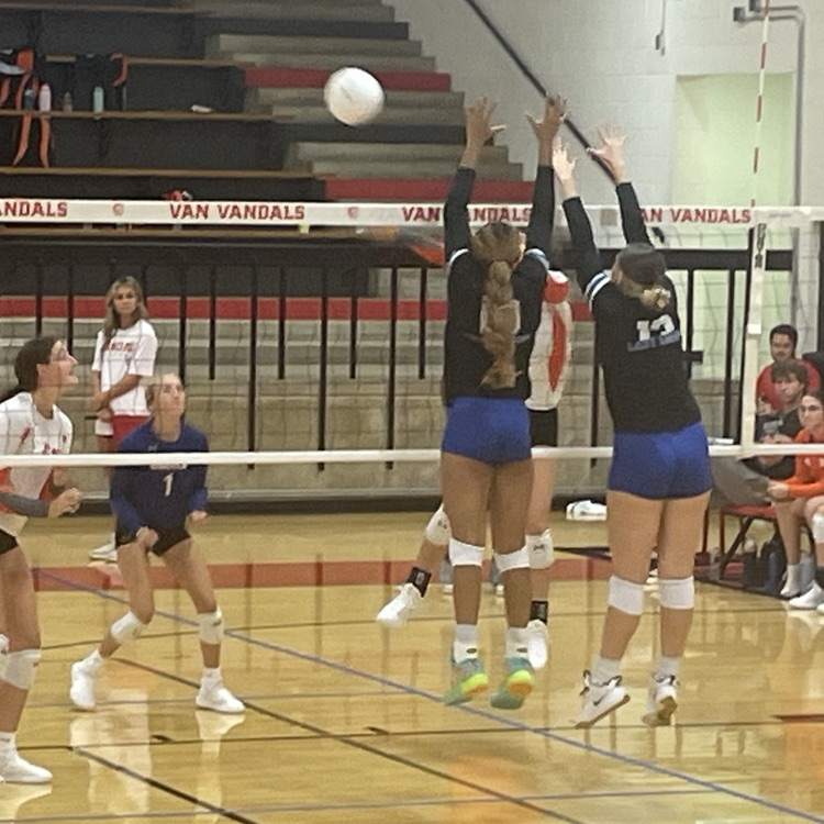 volleyball players blocking ball