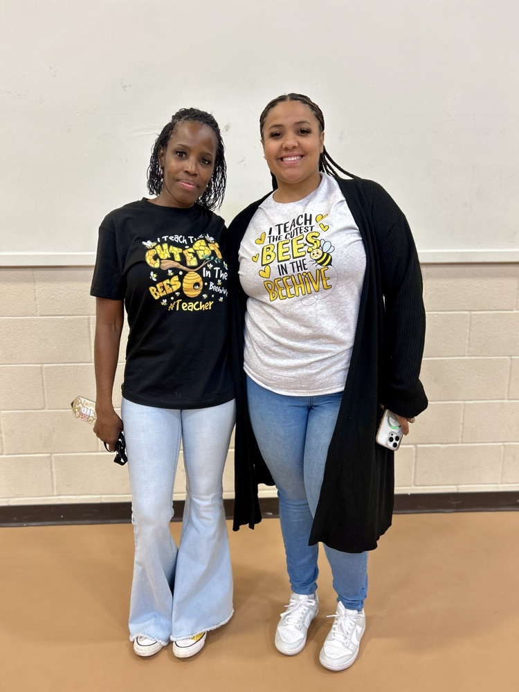 teachers smiling wearing bee teacher shirts