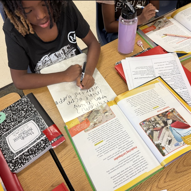students looking through their text to find evidence while riding