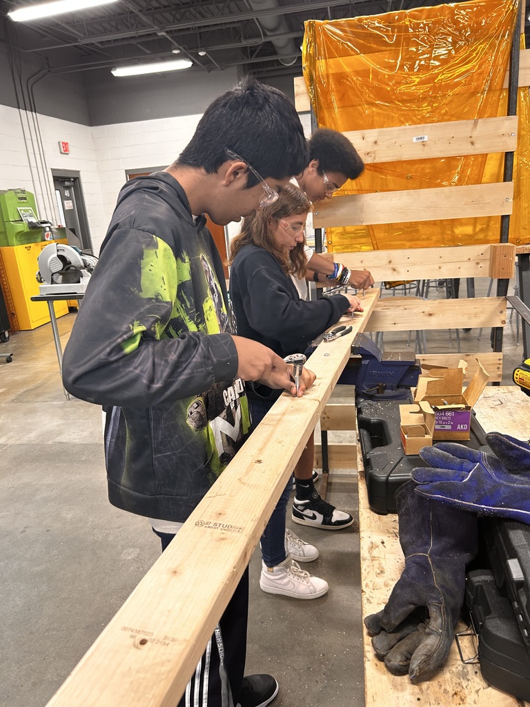 students learing to put screw into wood