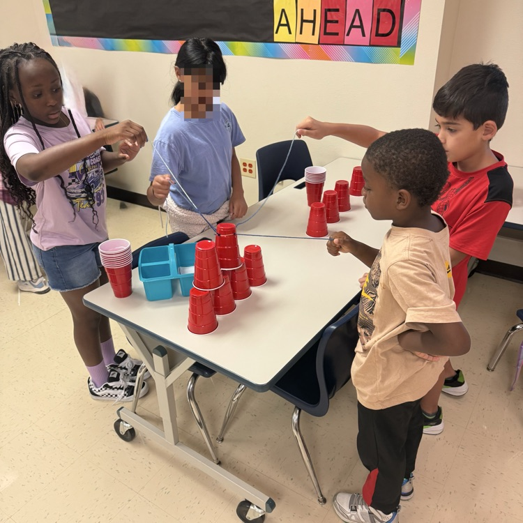 students working together to complete a cup stacking team building challenge 