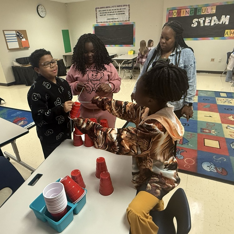 students working together to complete a cup stacking team building challenge 