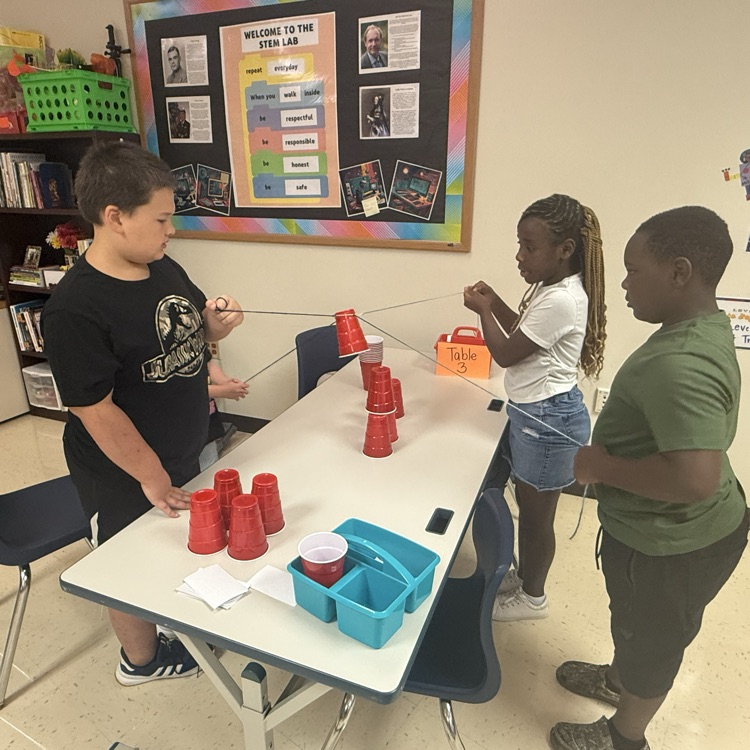students working together to complete a cup stacking team building challenge 