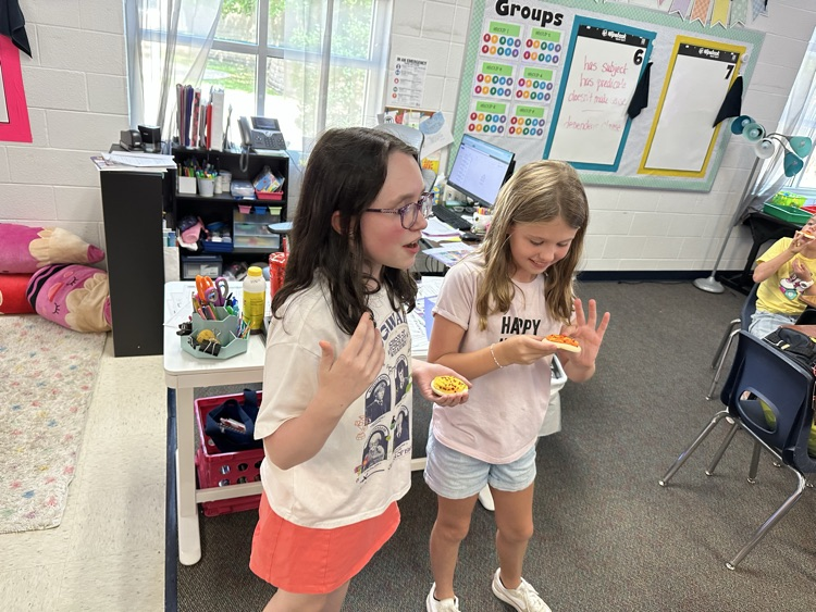 Two girls present ideas to their class.