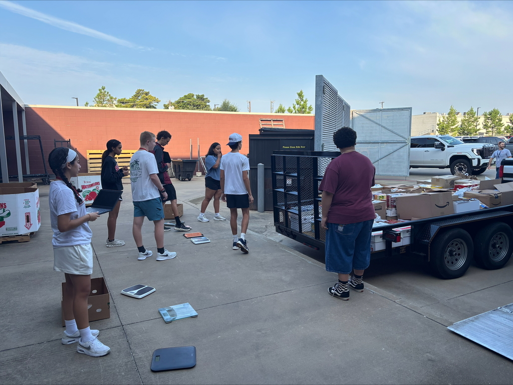 Tyler Legacy students loading food from the food drive into trucks for donation
