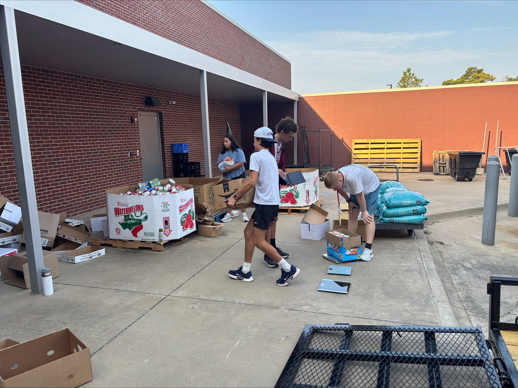 Tyler Legacy students loading food from the food drive into trucks for donation
