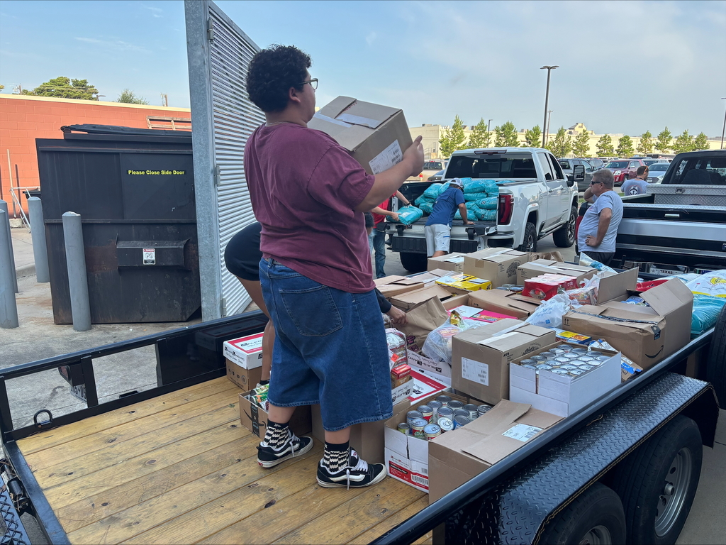 Tyler Legacy students loading food from the food drive into trucks for donation