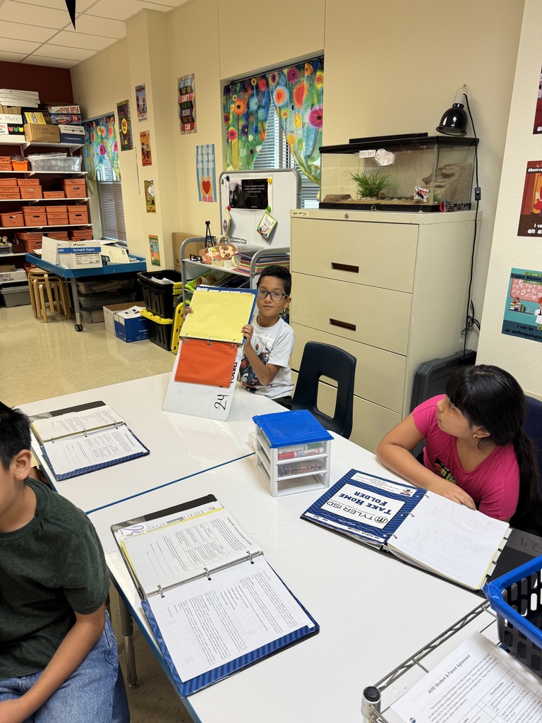 Student showing where they will put their AVID stickers in data notebook 