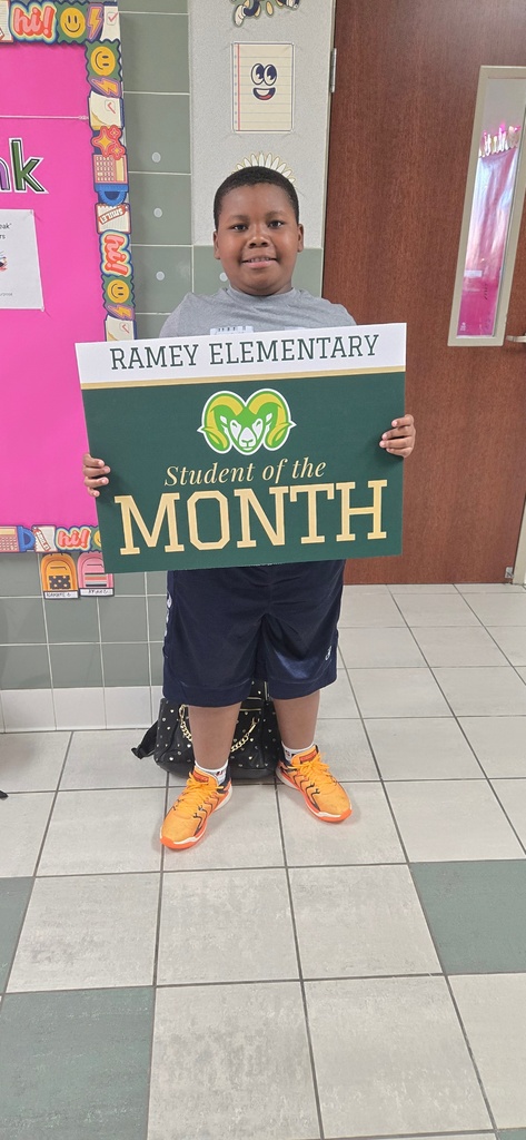 Child holding sign that says Student of the Month