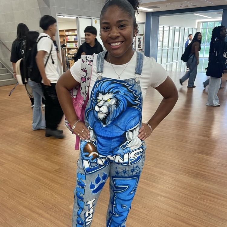 student in painted overalls