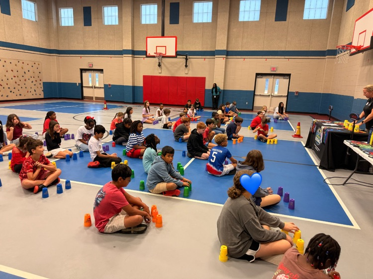 5th grade students listening to a guest speaker talk about cup stacking.