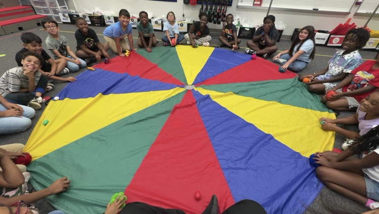 Second grade students sitting around a beat passing activity.