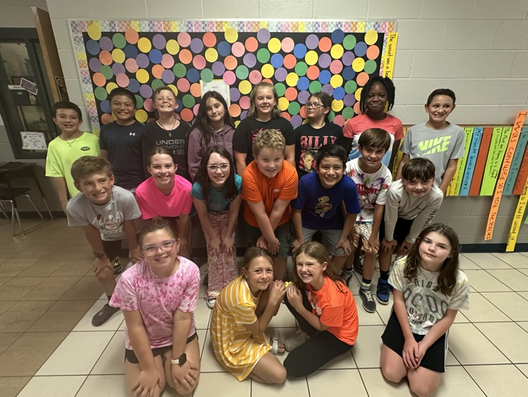 Group of 15 5th grade students standing in group in the hall.