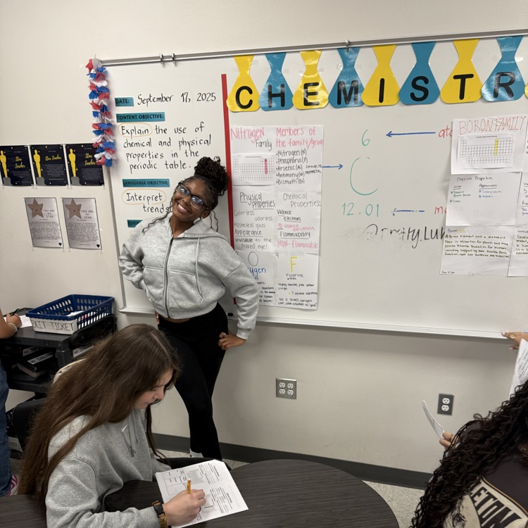 student posing with poster
