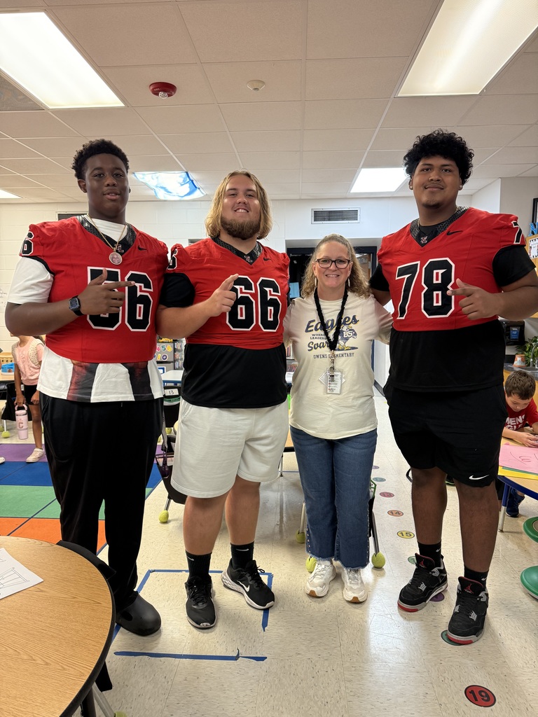 Football players posing with teacher.