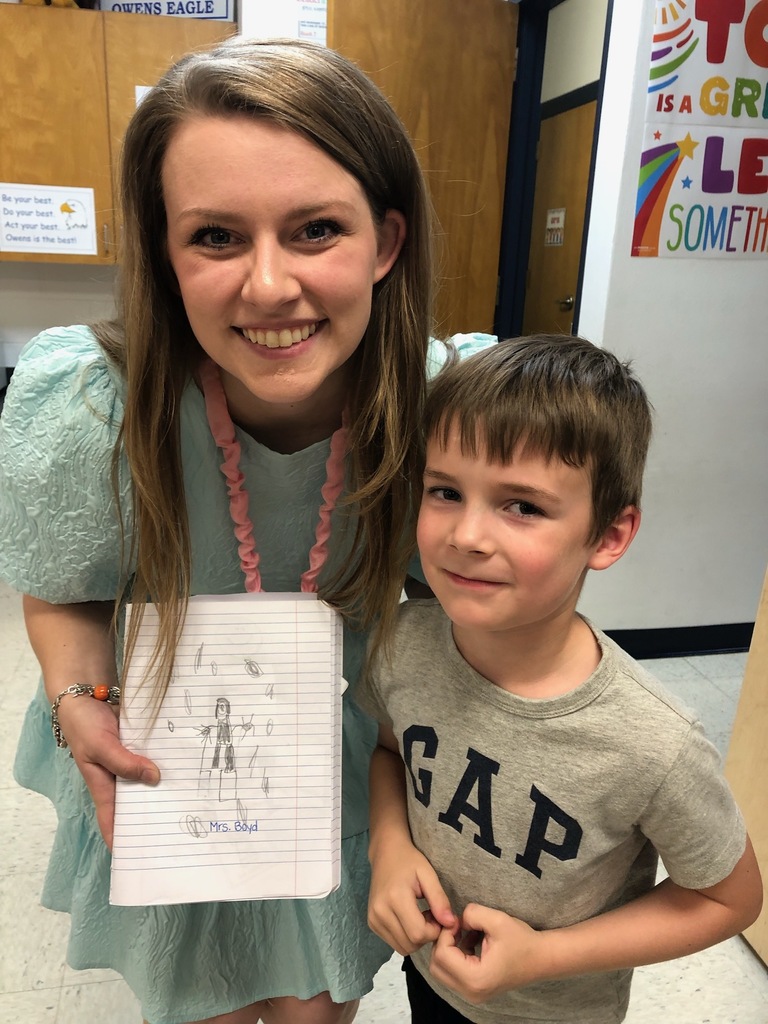 Student holding a picture of the librarian that he drew.