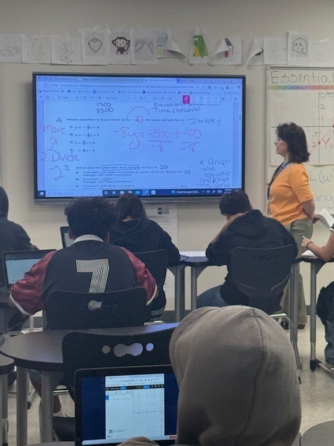 teacher at board working math problem