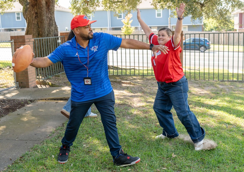 Principals have fun throwing a football at National Principals Month celebration.