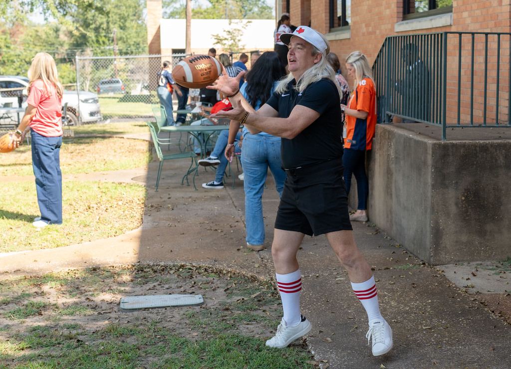 Bobby Markle catches football at National Principals Month celebration.