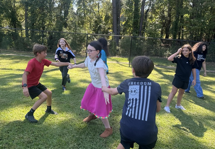 a group of kids playing tug-o-war outside