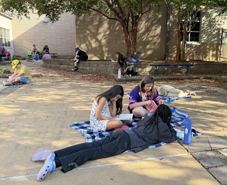 a group of kids reading around a courtyard