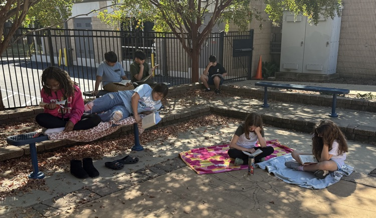 a bunch of kids reading around a courtyard