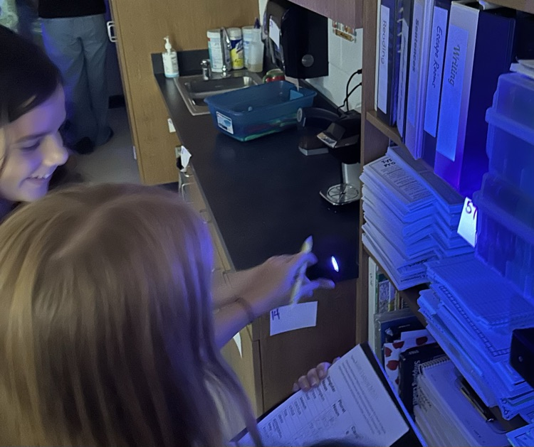 two boys looking for things with a black light flashlight