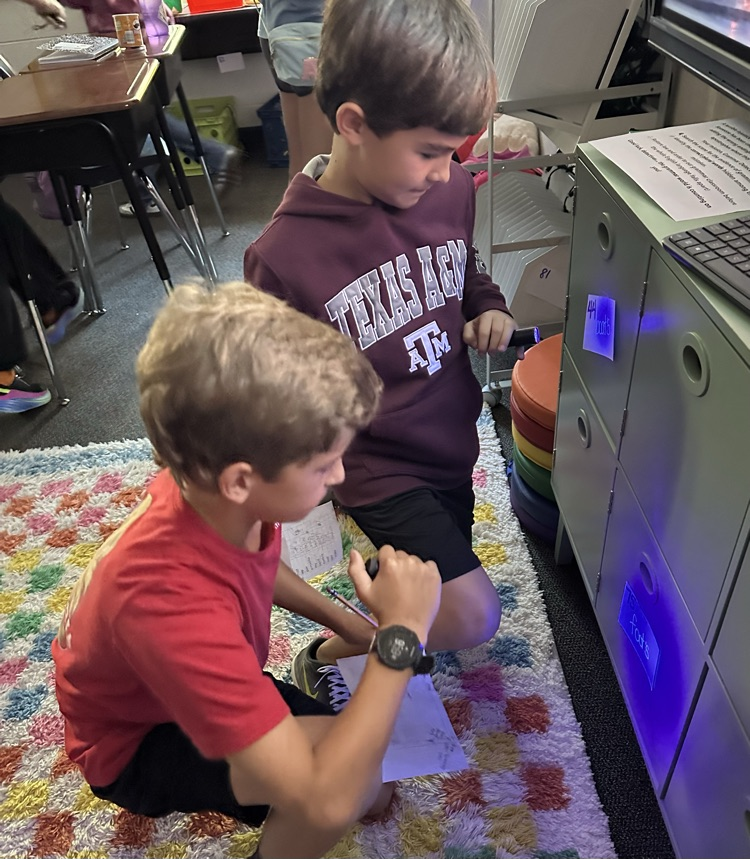 two boys looking for things with a black light flashlight