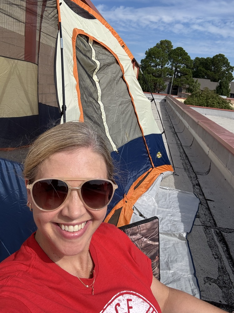 Mrs. OβNeal sitting in front of her tent on the school roof