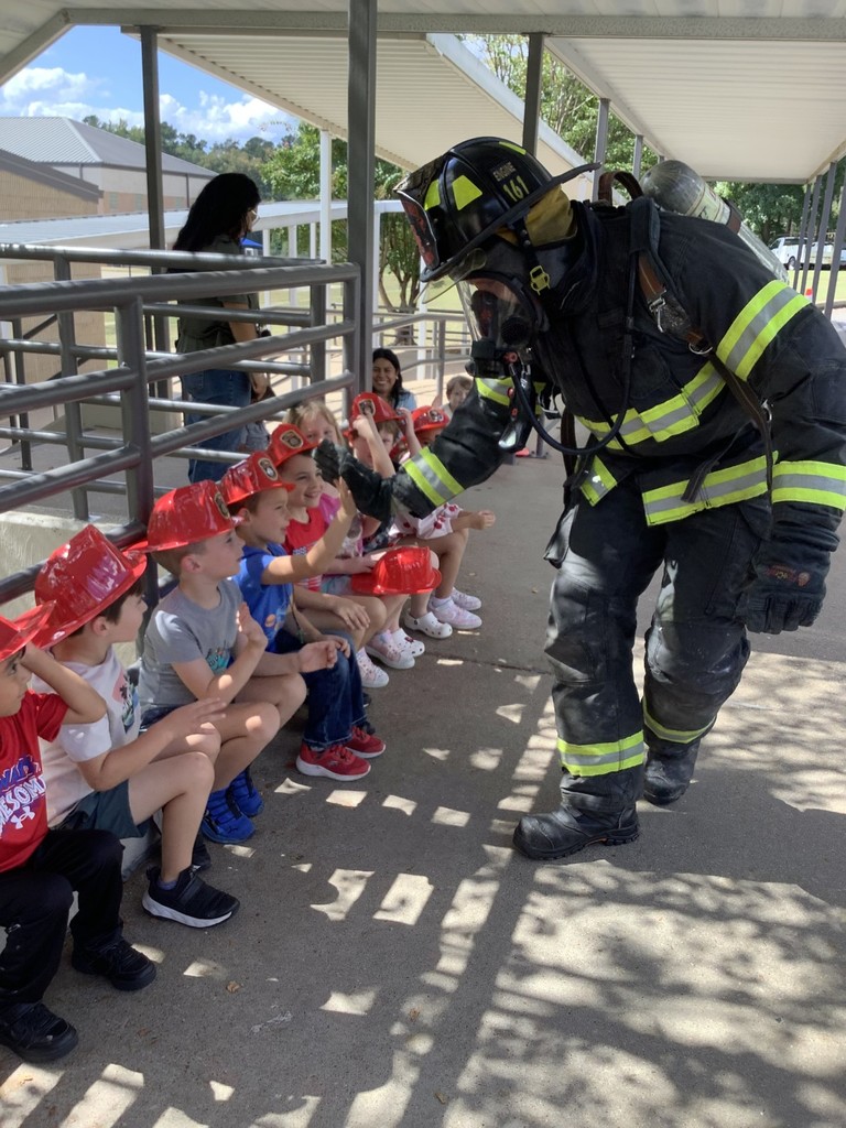 Fireman giving a high five to students.