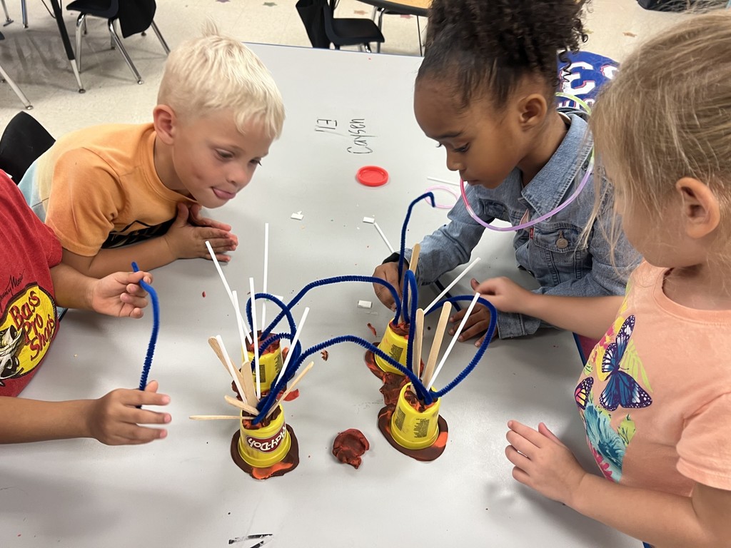 Students building STEAM activities with playdo and other materials.