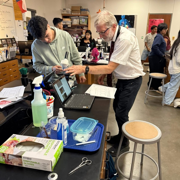 student and teacher at microscope 