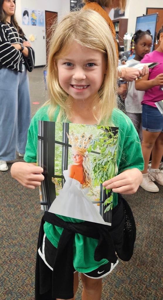student holding an invitation to the queens tea