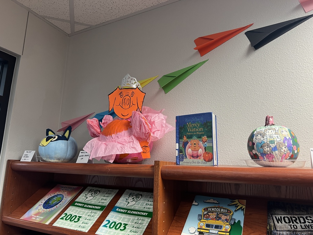 Decorated pumpkins on a book shelf