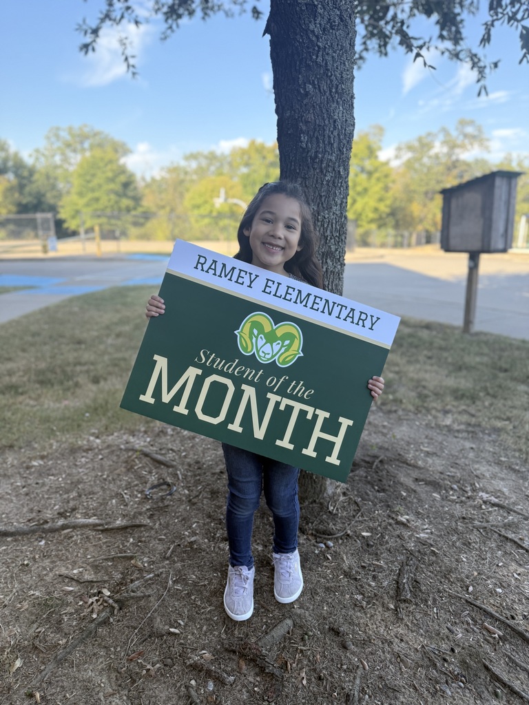 Little girl holding sign by tree