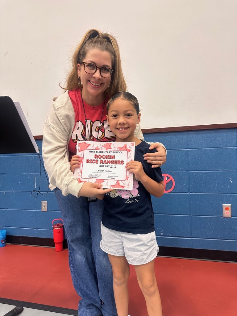 student and teacher with award