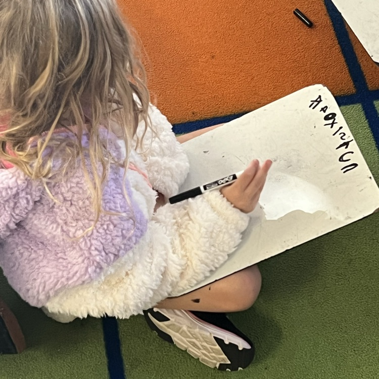 kindergarten students working on writing full sentences with whiteboards and markers