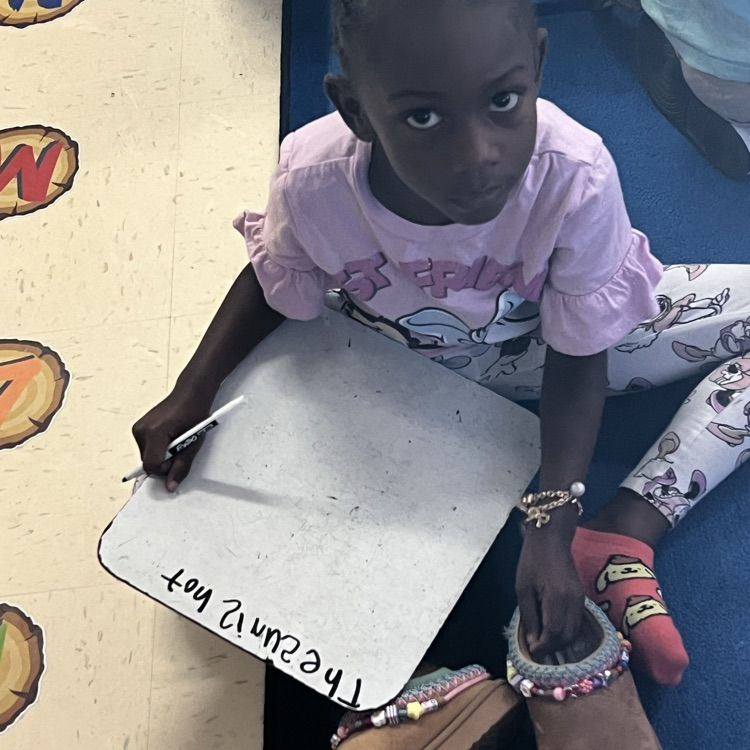 kindergarten students working on writing full sentences with whiteboards and markers